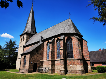 Das Foto zeigt die Evangelische Kirche in Hünxe-Drevenack unter strahlent blauem Himmel.